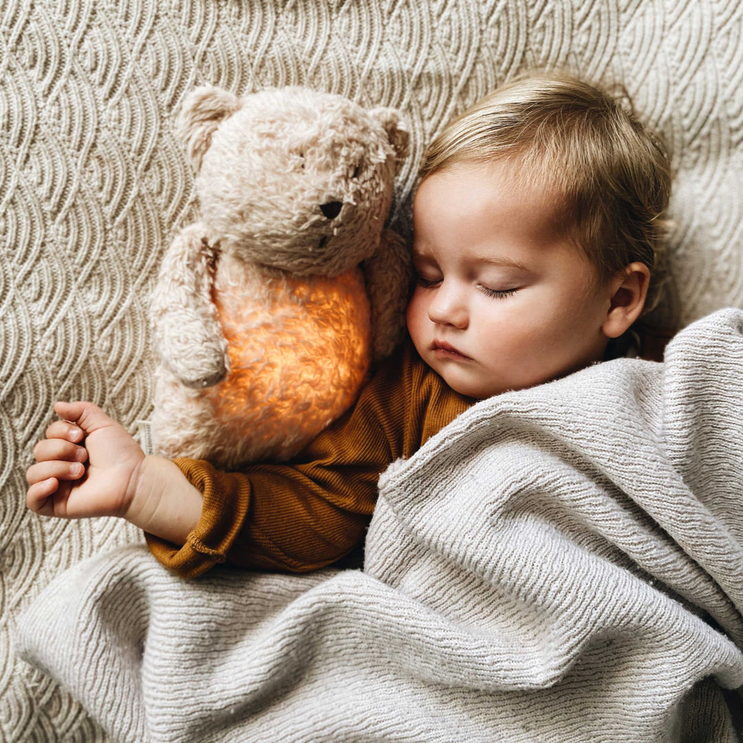 Bambino neonato dormento con orsetto moonie
